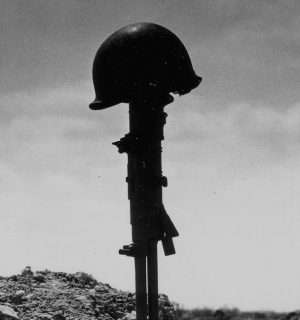 Relato corto, Dulce Jenny. Una metralleta clavada en el suelo con un casco militar encima.