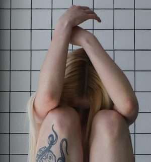 Relato corto, Superviviente. Una mujer encogida que transmite dolor y pena.